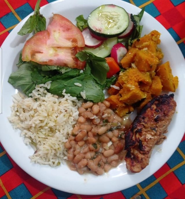 Prato com arroz, feijão, abóbora, frango grelhado e salada de folhas, tomate, pepino e rabanete