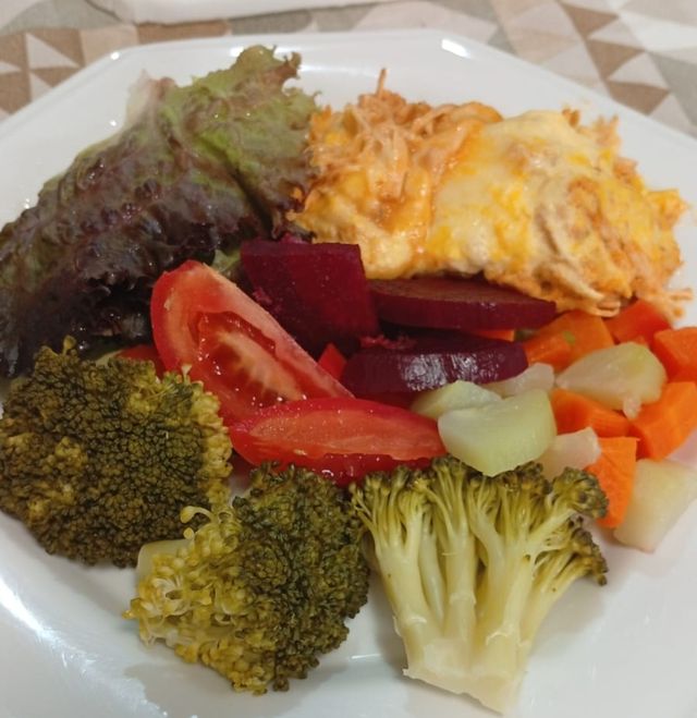 Prato com frango gratinado, brócolis, beterraba, cenoura, chuchu e salada